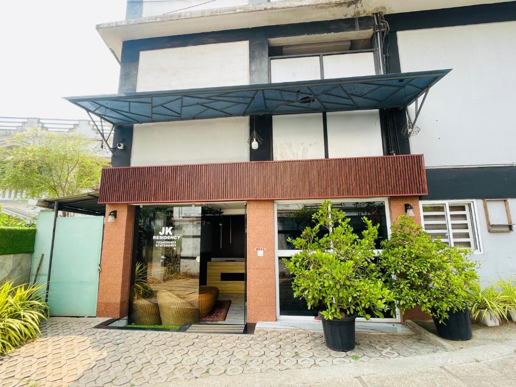 a store front of a building with plants in front at JK Residency in Kunnamangalam