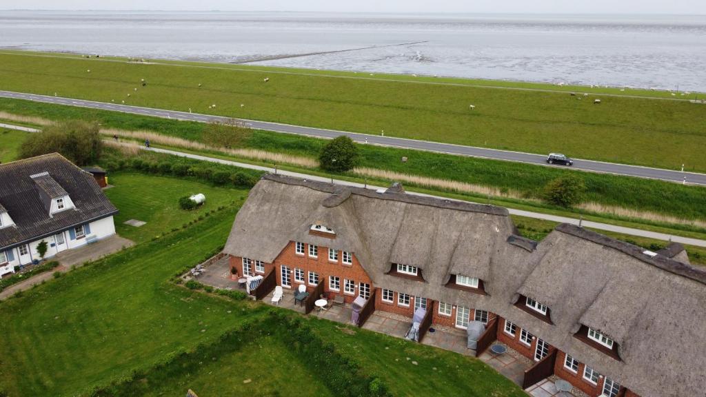 an aerial view of a house with the ocean at Friesenhof am Deich in Nordstrand