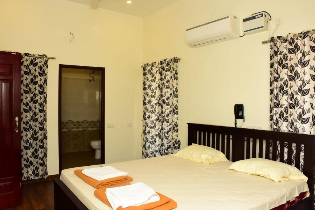 a bedroom with a bed with towels on it at Skandavanam in Tiruvallūr
