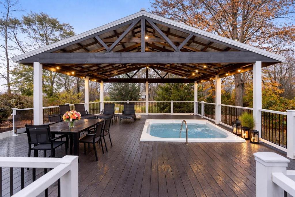 a pavilion with a table and a pool on a deck at Blue Star 2 Location Location 12 person hot tub in Douglas