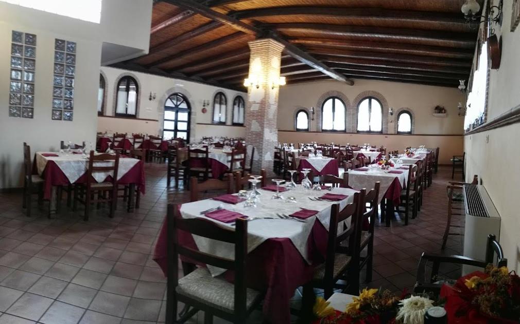 un comedor con mesas y sillas en un edificio en B&B Valle Gio' en Magliano deʼ Marsi