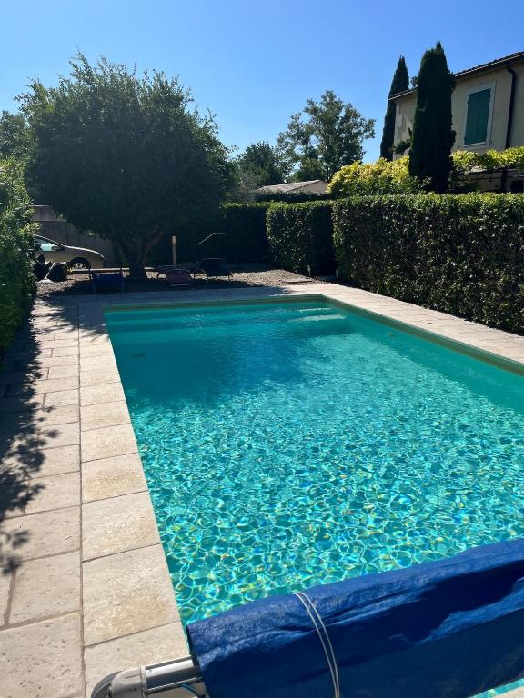 a swimming pool with blue water in a yard at Charming studio in a residence in Provence in Graveson
