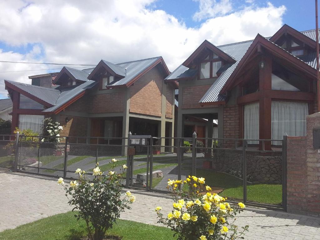 a house with a fence in front of it at Del Sur Apart in Esquel