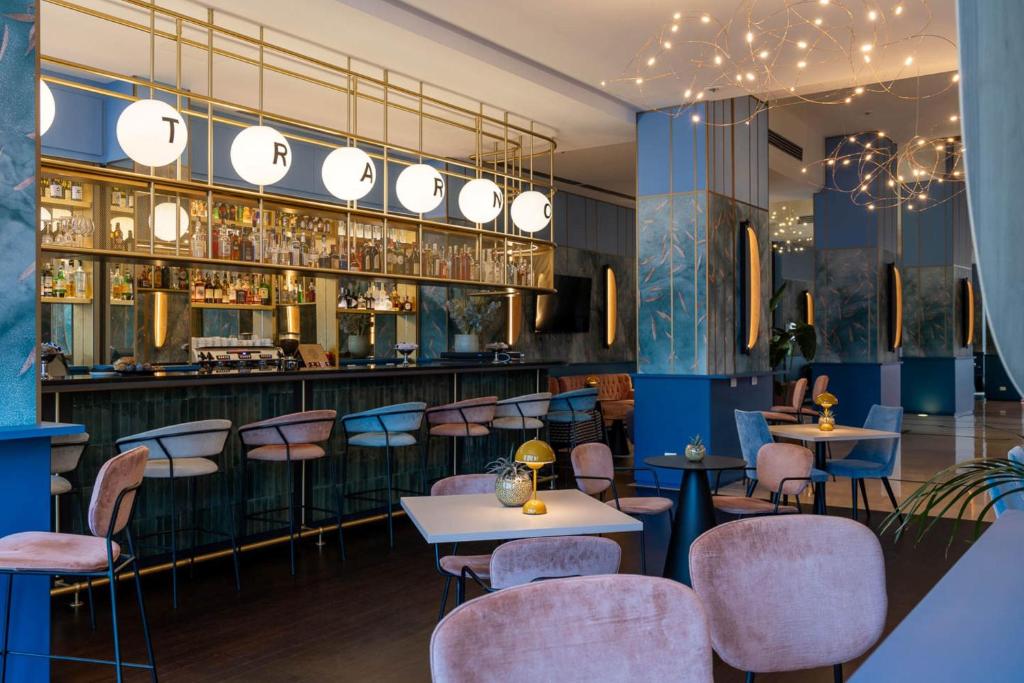 a restaurant with purple chairs and a bar at DoubleTree by Hilton Florence Metropole in Florence