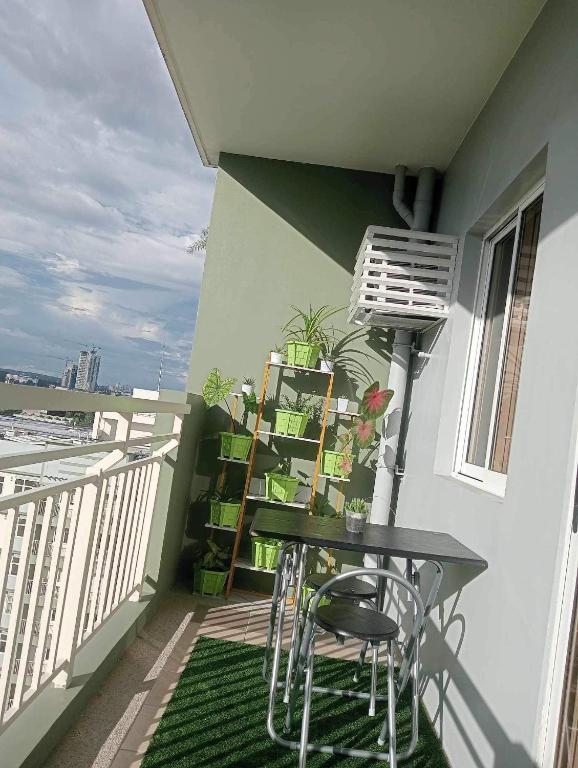 a balcony with a table and chairs and a book shelf at Verdon Parc Butterfly Haven in Davao City
