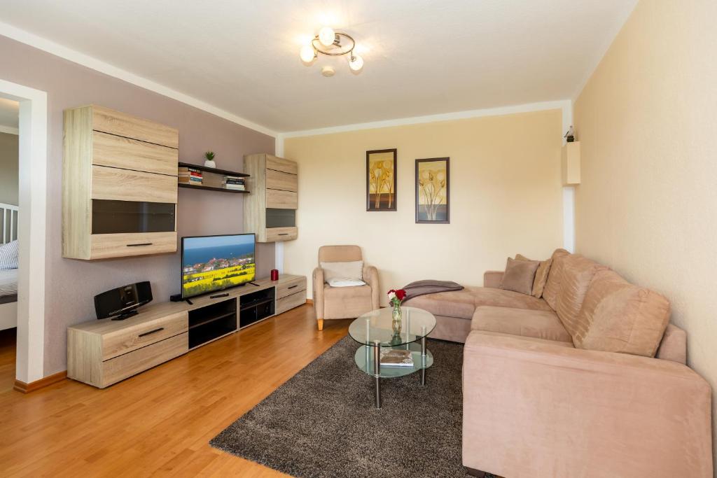 a living room with a couch and a tv at Bungalow Becker "Am Feldrand" in Jennewitz