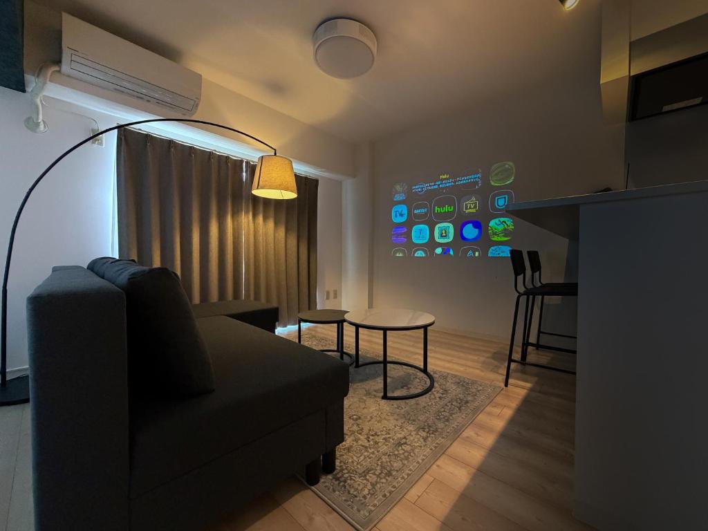 a living room with a couch and a table at BALCOM STAY Hiroshima Deshio in Hiroshima