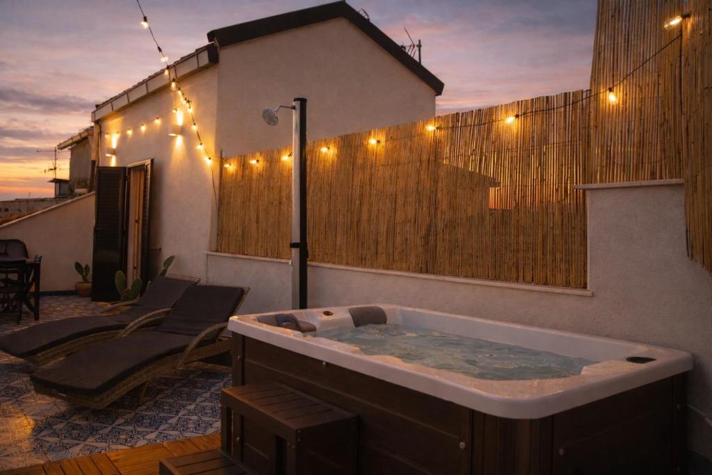 a jacuzzi tub on a patio with a fence at Zisa Top Romantic Terrace & Private outdoor Jacuzzi in Palermo