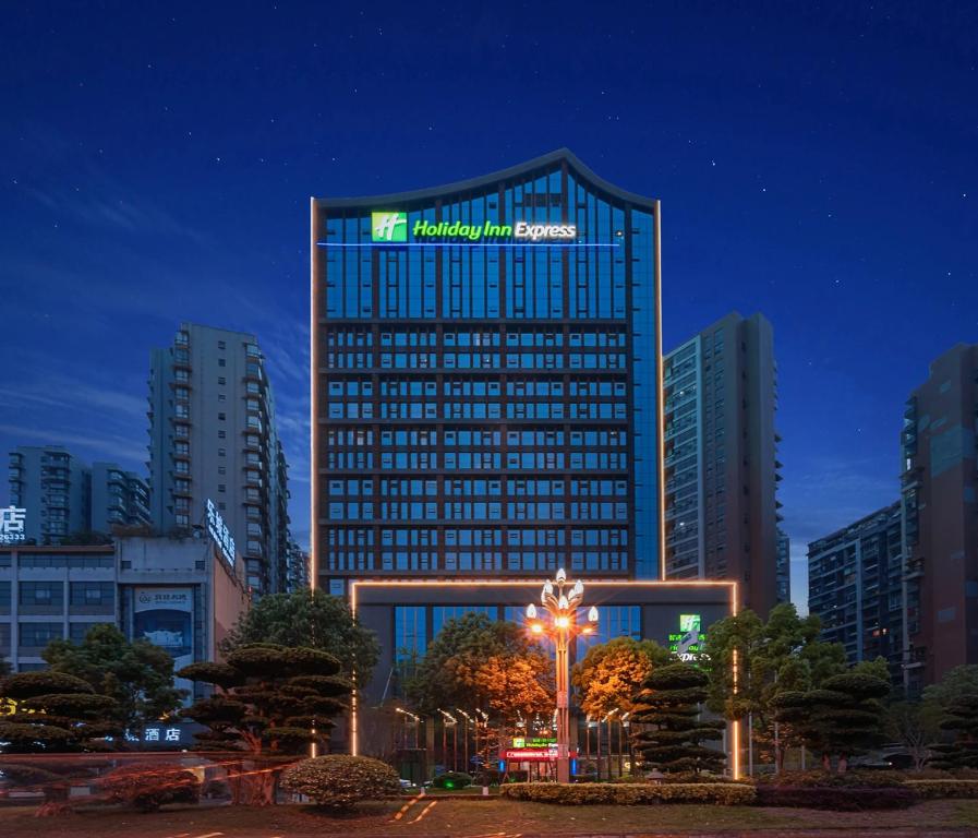 a tall building with a sign on the top of it at Holiday Inn Express Leshan City Square by IHG - High Speed Rail and Leshan Giant Buddha in Leshan