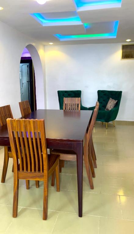 a dining room with a wooden table and chairs at The John Apartment in Murtala Muhammed International Airport