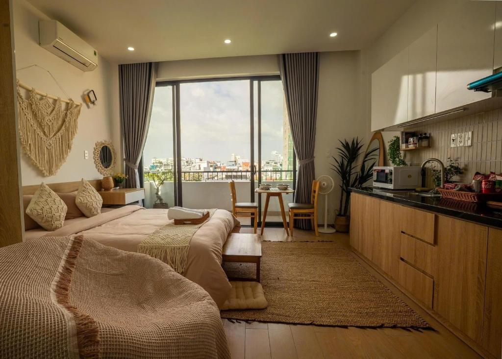 a bedroom with two beds and a kitchen with a view at BaBô Homestay Da Nang in Danang
