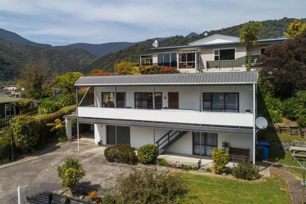 an aerial view of a house with mountains in the background at Harbour View on Buller in Picton
