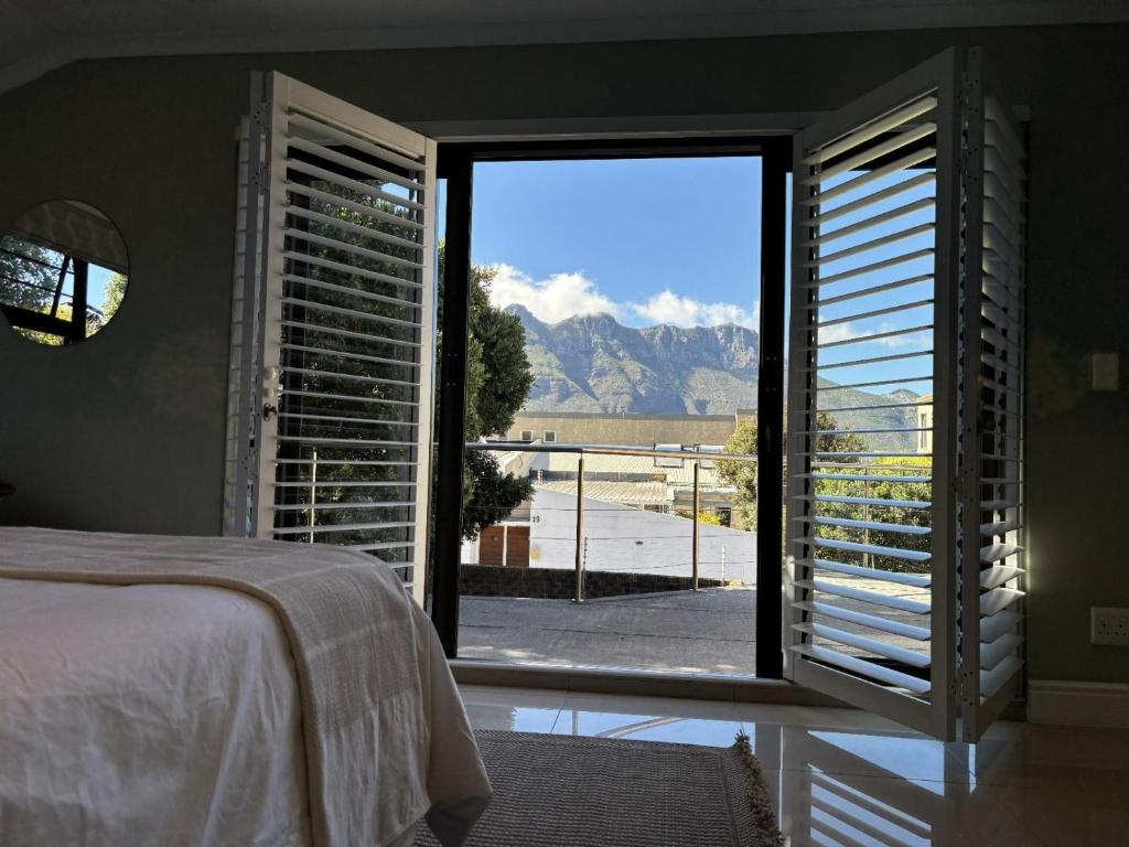 a bedroom with a bed and a large window with a view at Leehaven in Hout Bay