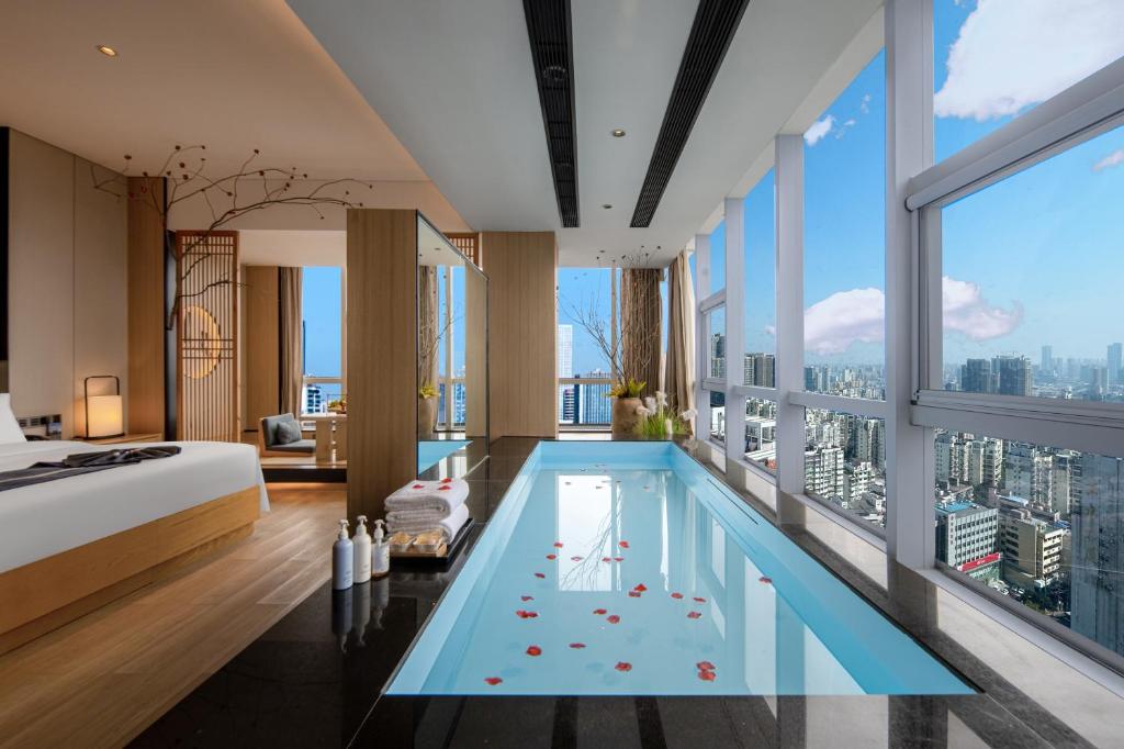 a hotel room with a swimming pool in the middle of a bedroom at Changsha Rama-da by Wyndham Wuyi Square-Near Metro-Business Center in Changsha