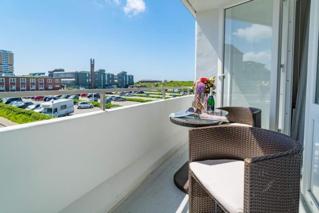 a balcony with a table and chairs and a view of a city at Weststrand, App 11 "Seewind" in Westerland