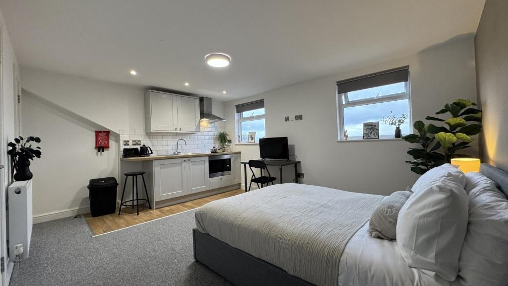 a bedroom with a large bed and a kitchen at Camden St Accommodation in Derby