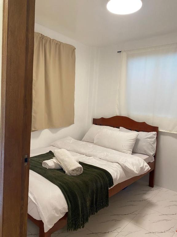 a bedroom with a bed with a green blanket on it at Entire home in General Luna in General Luna