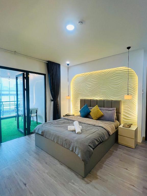 a bedroom with a large bed with a large headboard at Pony Bliss Haven - Sư Vạn Hạnh in Ho Chi Minh City