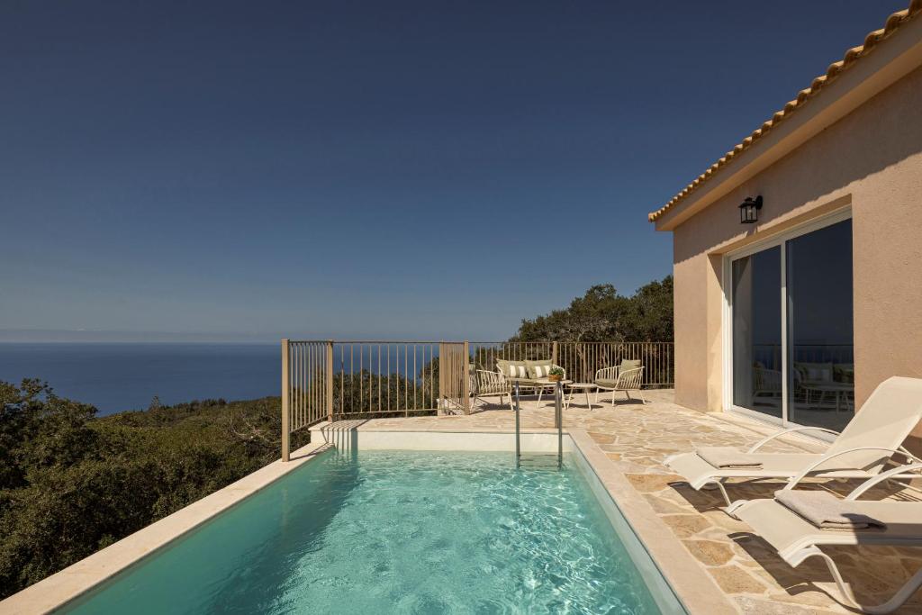 a swimming pool with a view of the ocean at Magganos Sunset Villas in Fiskardo