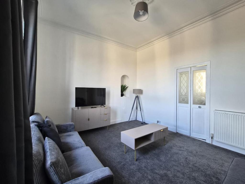 a living room with a couch and a tv at Modern Top Floor 2BR apartment in Montrose