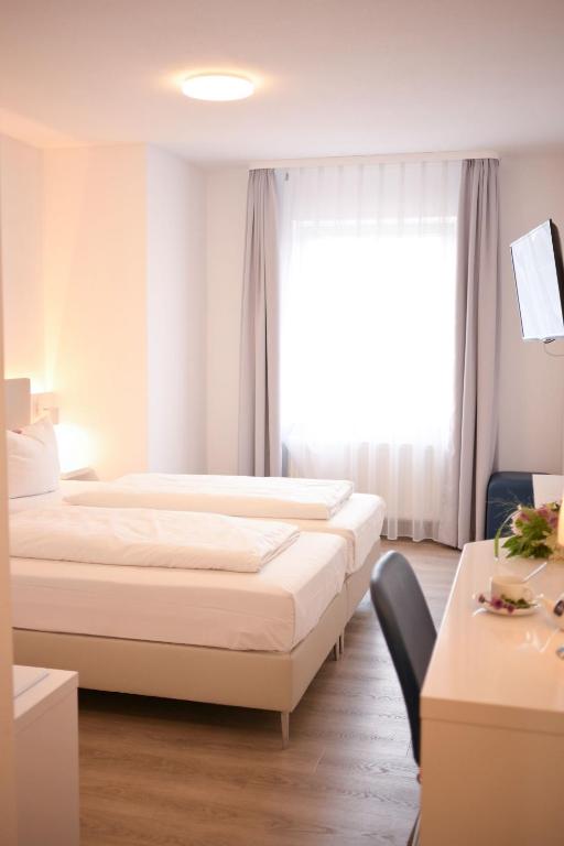 a hotel room with two beds and a window at Hotel Günter in Lenting