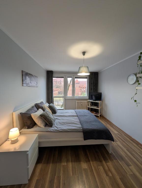 a bedroom with a large bed and a window at Castle View Apartment in Malbork