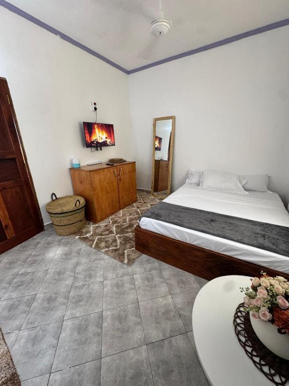 a bedroom with a bed and a table and a mirror at nova nest in Watamu