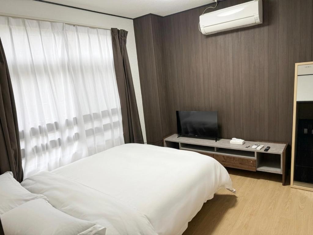 a hotel room with a bed and a television at 亀井町Stay201 in Takamatsu