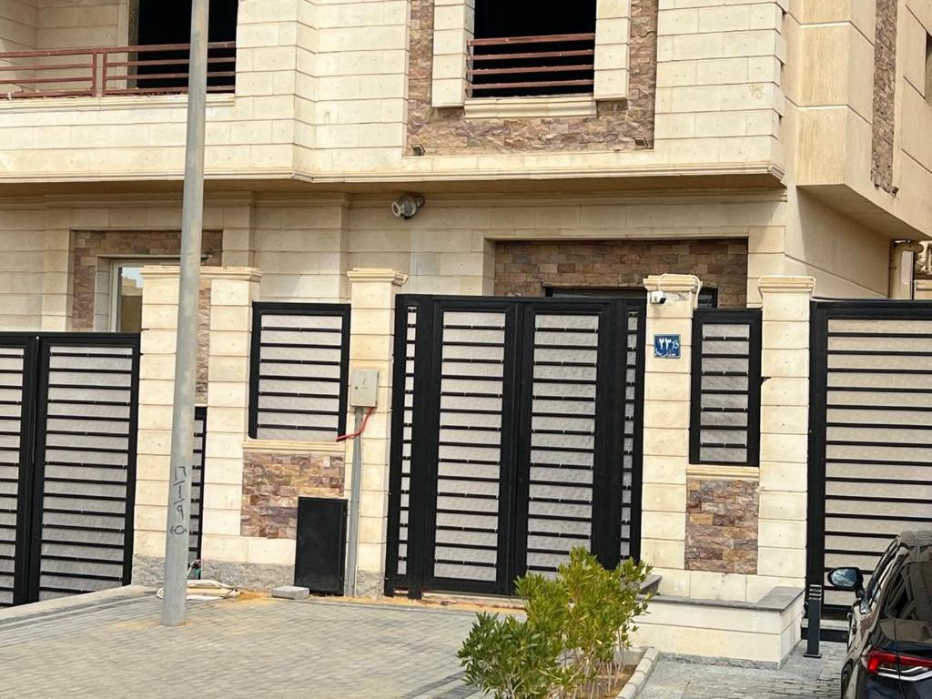 ein Gebäude mit schwarzen Fensterläden an der Seite in der Unterkunft Aman Villa in New cairo