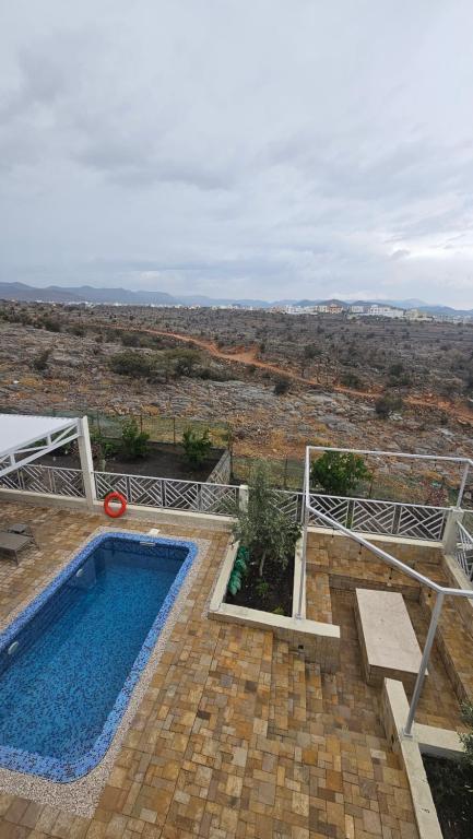 a swimming pool with a view of the desert at Horizon Villa in Qurayyah