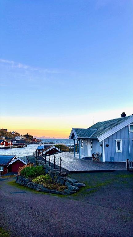a building with a dock next to a body of water at Nordic Elegance Retreat in Sørvågen