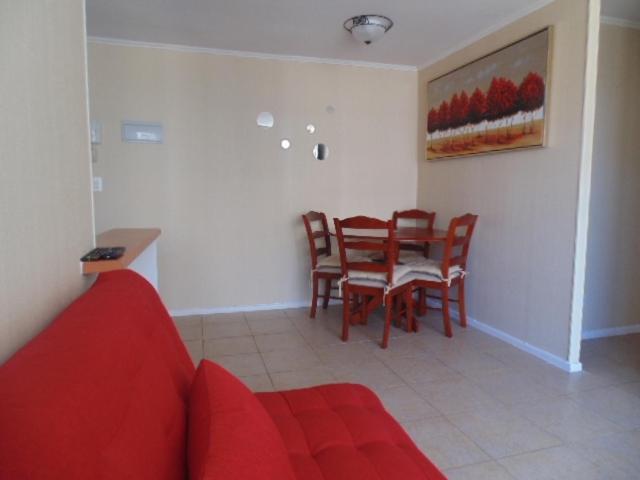 sala de estar con sofá rojo y mesa en Amoblados Copiapo, en Copiapó