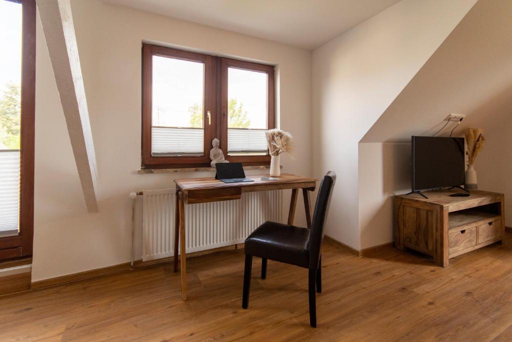 a desk with a laptop and a chair in a room at Wolke 7 – PEAK Andreasberg in Sankt Andreasberg