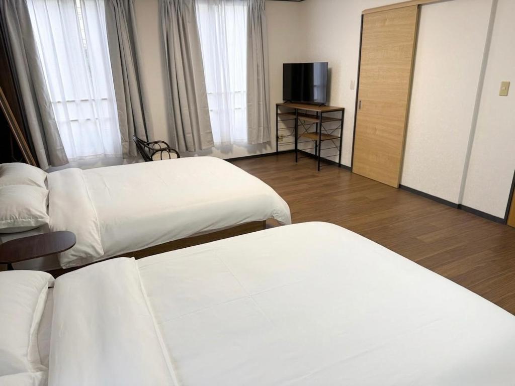 a hotel room with two beds and a television at 亀井町Stay202 in Takamatsu