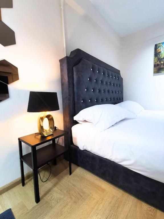 a bedroom with a bed and a table with a lamp at The One Hotel in Pattaya