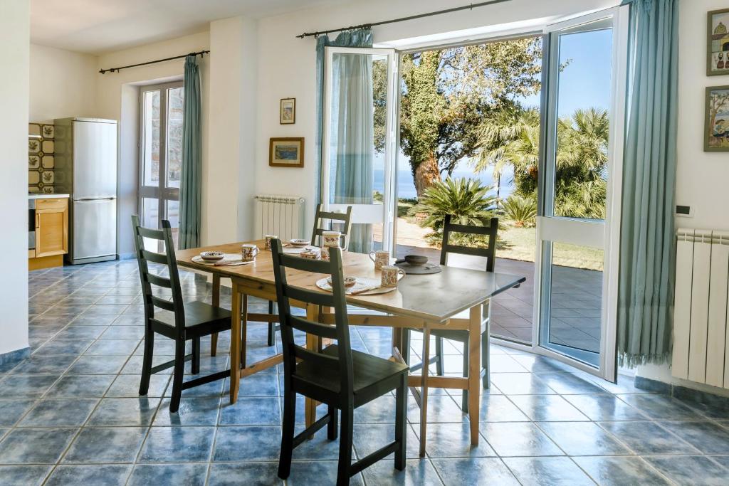a kitchen and dining room with a wooden table and chairs at Casa del passero - Villa with Infinity Garden and Sea View in Forio d'Ischia