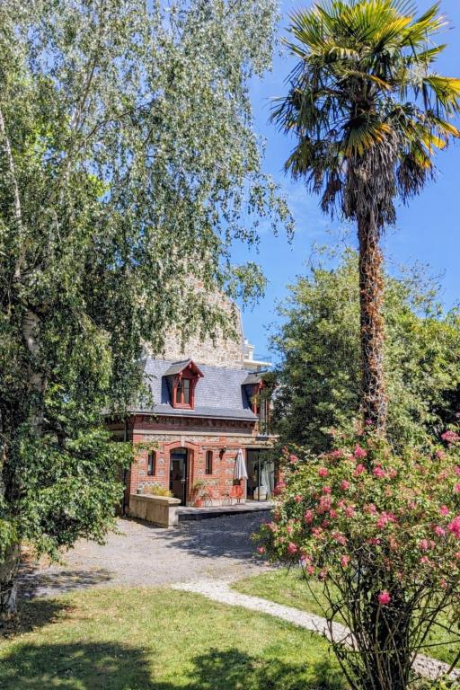 a palm tree in front of a house at Charmante petite maison d'exception classée in Saint-Brieuc