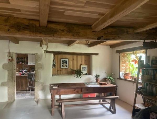 a living room with a wooden table and a window at Longère en campagne in Maisonnay