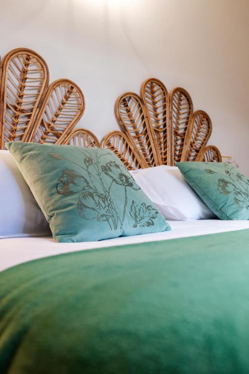 a bed with green and white pillows on it at Apartamento Bautista Centro in Cangas de Onís