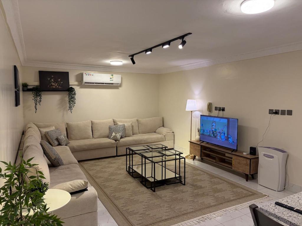 a living room with a couch and a flat screen tv at ترف in Medina