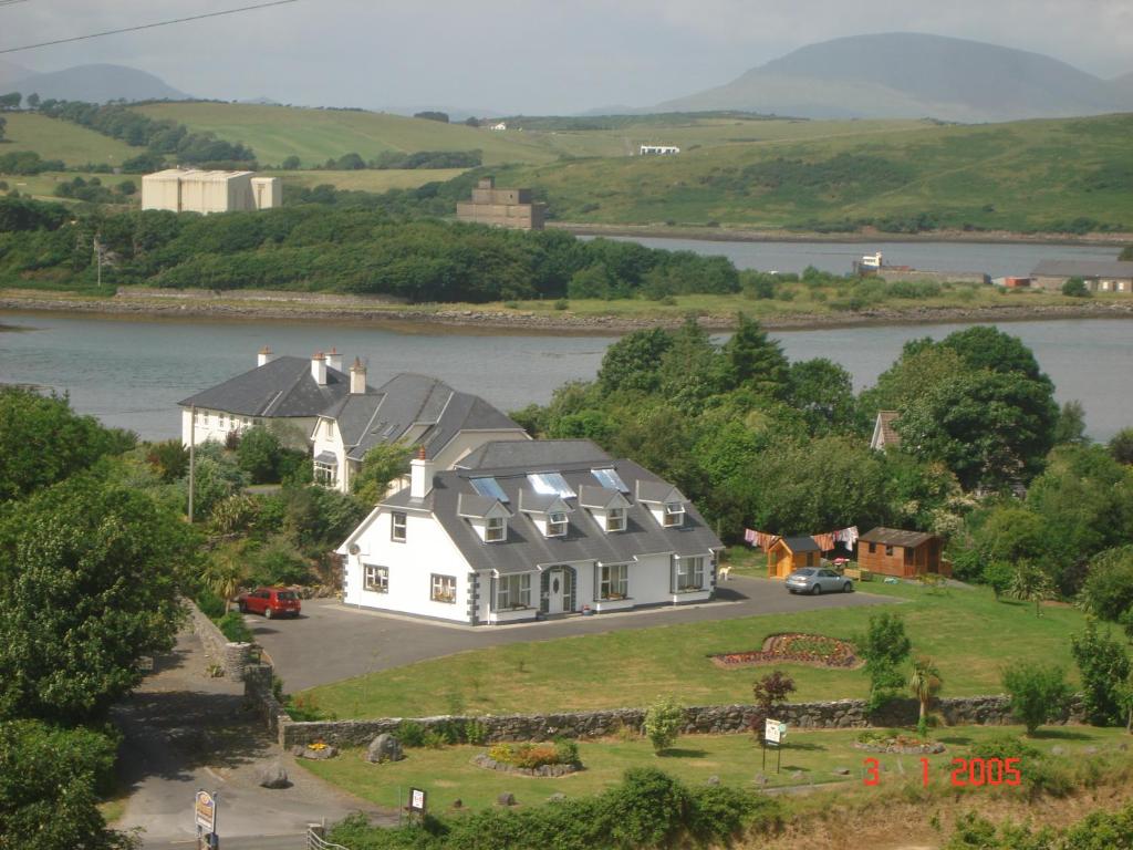 a large white house on a hill next to a river at Rosmo House B&B in Westport