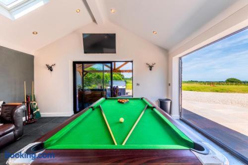a pool table in a living room with a large window at Greenwood House in Whitegate