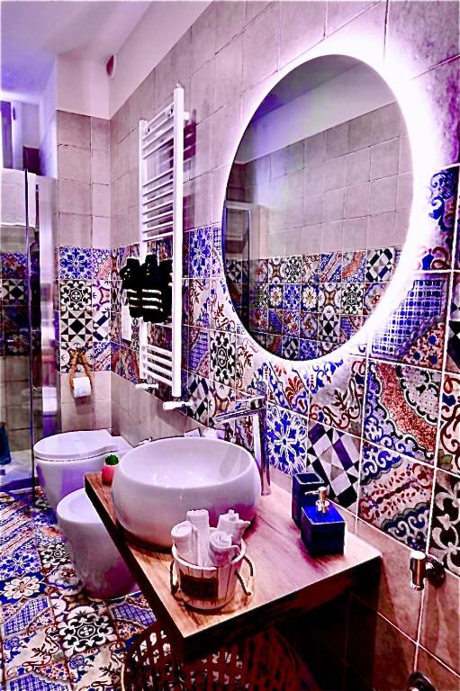 a bathroom with a tub and a toilet and tiles at La Macchia sui Sassi in Matera