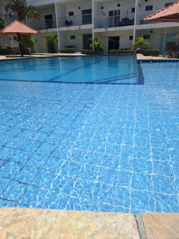 a large swimming pool in front of a building at Flat Mar doce lar in Conde
