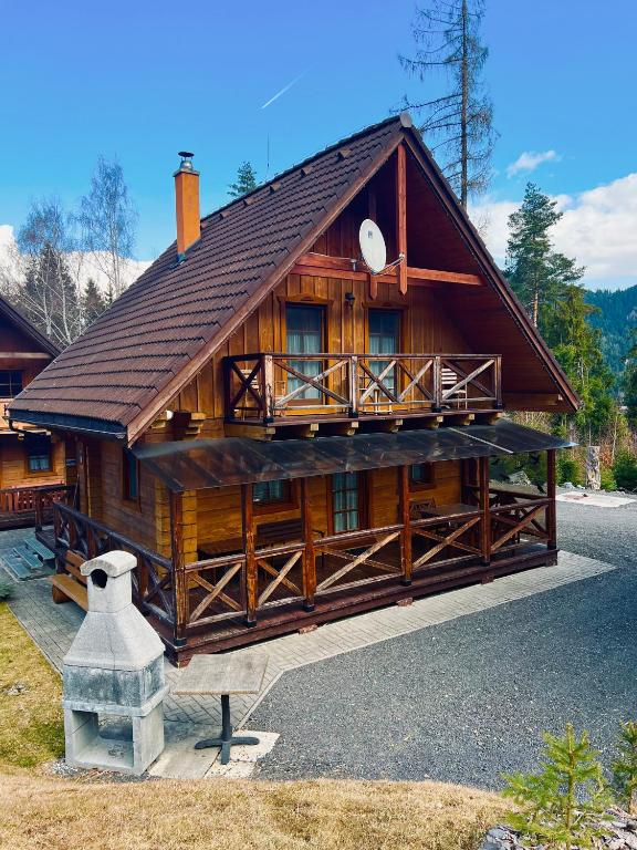 a large wooden cabin with a large balcony on it at Zruby Liptovský Ján in Liptovský Ján