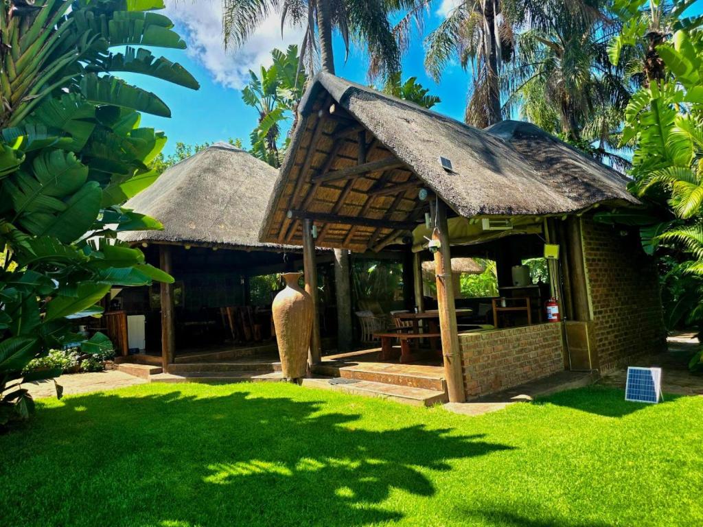 a small hut with a thatched roof in a yard at Lapa Phanzi Game Lodge in Modimolle