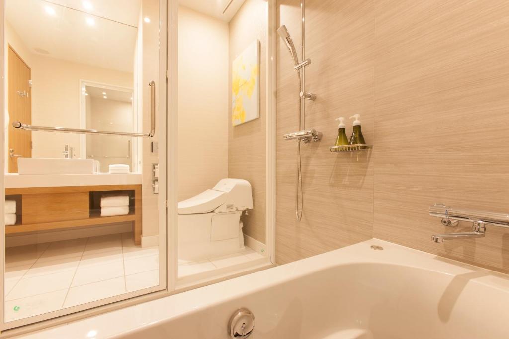 a bathroom with a tub and a shower and a sink at Nagoya JR Gate Tower Hotel in Nagoya