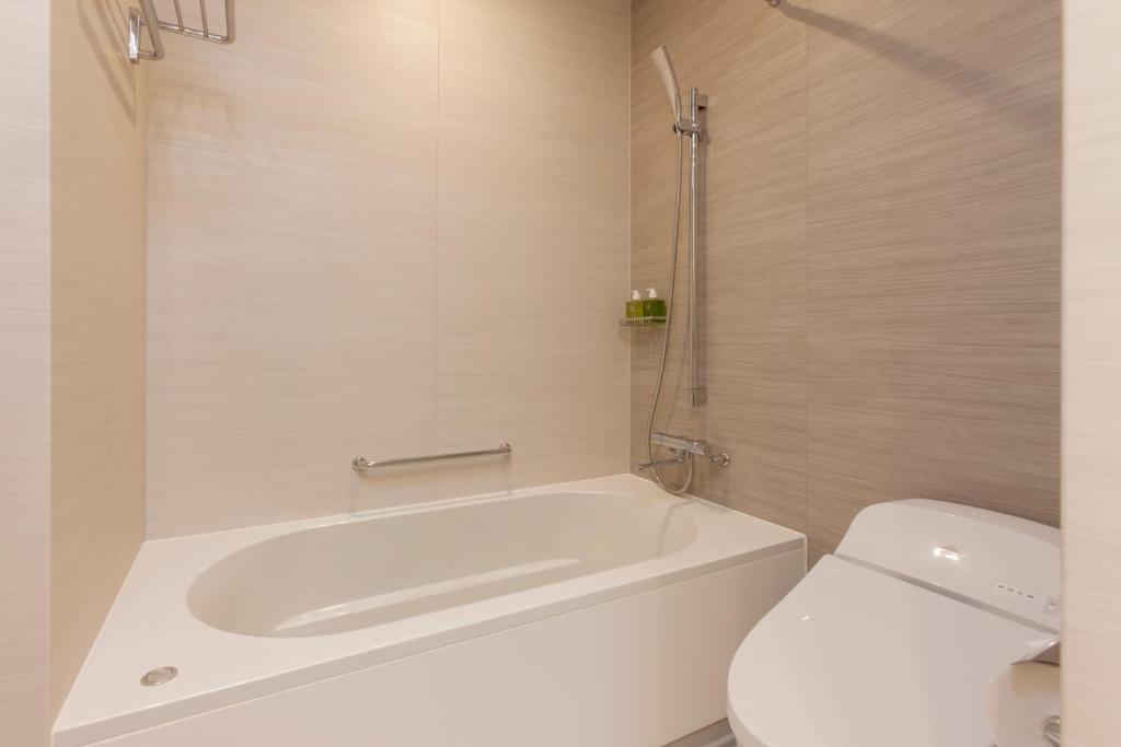 a bathroom with a white tub and a toilet at Nagoya JR Gate Tower Hotel in Nagoya