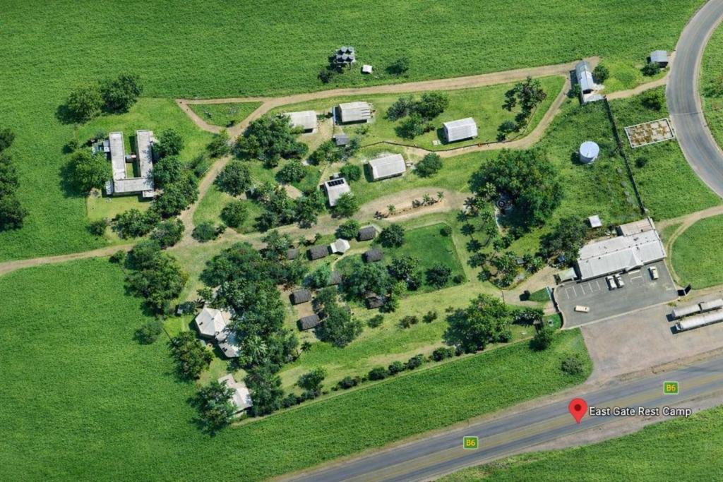 an aerial view of a house with trees and a road at East Gate Rest Camp in Buitepos