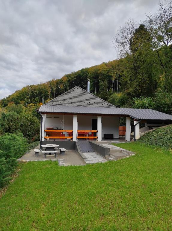 a pavilion with a bench and a table in a park at Forest Residence Miskolc in Miskolc